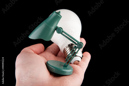 image of miniature lamp bulb hand dark background  photo