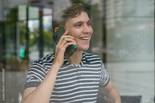 Portrait of young caucasian man in casual clothes making phone call