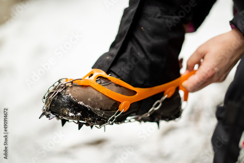 Close up of snow shoes and shoe spikes in winter. 
Hiking, concept during outdoor winter trekking for better health. photo