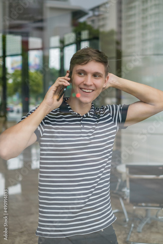 Portrait of young caucasian man in casual clothes making phone call © Aleksandr