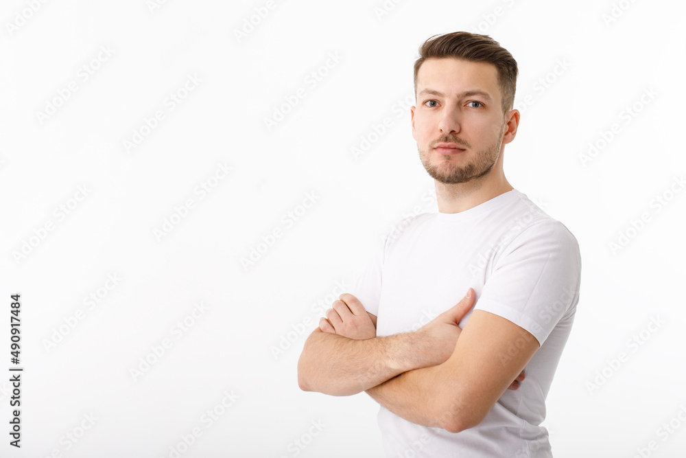 Portrait of a cheerful young man in a white T-shirt on a white background. The guy is standing looking at the camera and smiling. Portrait of a cheerful young man in a white T-shirt on a white background. The guy is standing looking at the camera and smiling.