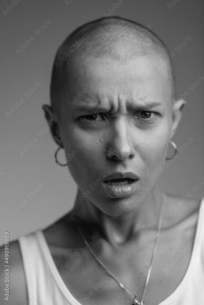 emotional studio portrait of a young attractive bald girl black and white image