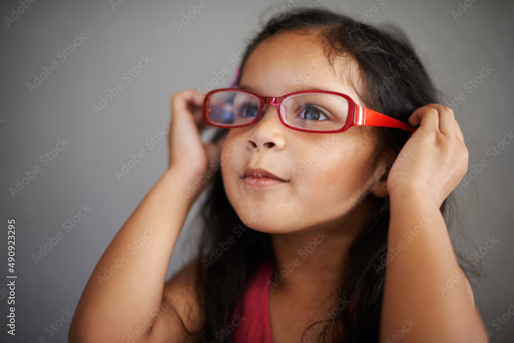 I think they suit me, dont you. Shot of a cute little girl trying on an adult pair of glasses. I think they suit me, dont you. Shot of a cute little girl trying on an adult pair of glasses.