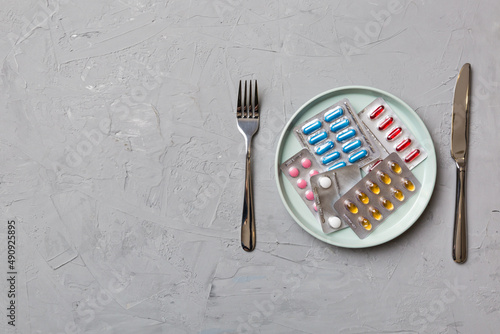 Many different weight loss pills and supplements as food on round plate. Pills served as a healthy meal. Drugs, pharmacy, medicine or medical healthycare concept photo