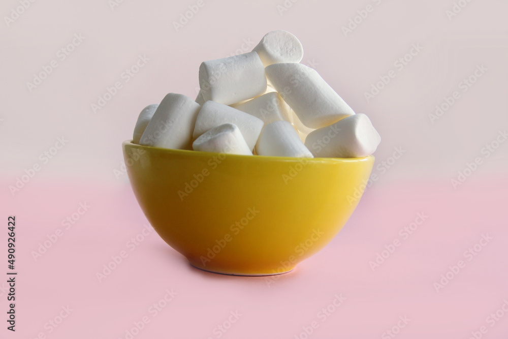 white marshmallow in a yellow plate on a pink background white marshmallow in a yellow plate on a pink background