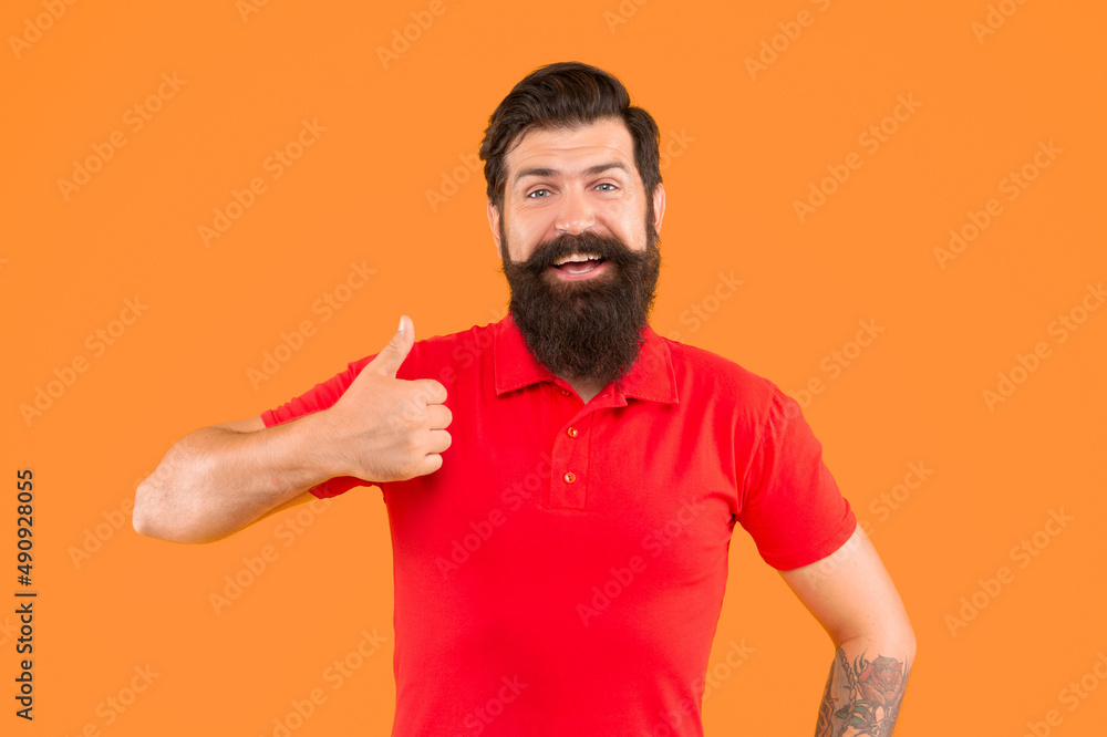 happy bearded man with moustache in tshirt showing thumb up on orange background, haircut happy bearded man with moustache in tshirt showing thumb up on orange background, haircut