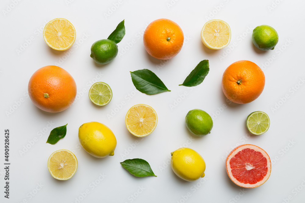 Flat lay of citrus fruits like lime, orange and lemon with lemon tree leaves on light colored background. Space for text healthy concept. Top view Flat lay of citrus fruits like lime, orange and lemon with lemon tree leaves on light colored background. Space for text healthy concept. Top view