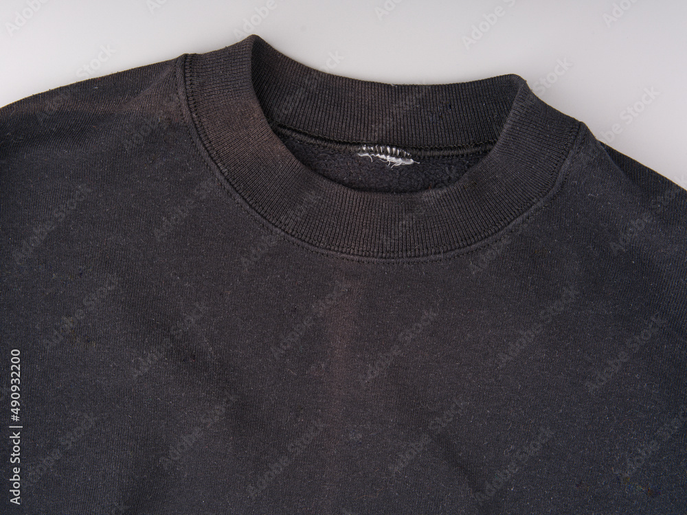 An old black battered hoodie without a hood. Top view An old black battered hoodie without a hood. Top view