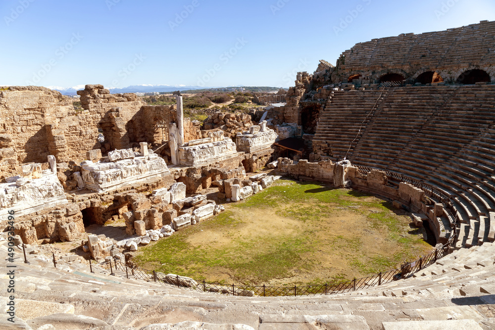 Beautiful view of ancient amphitheatre in Side, Turkey. Antique ruined arena on sunny day.