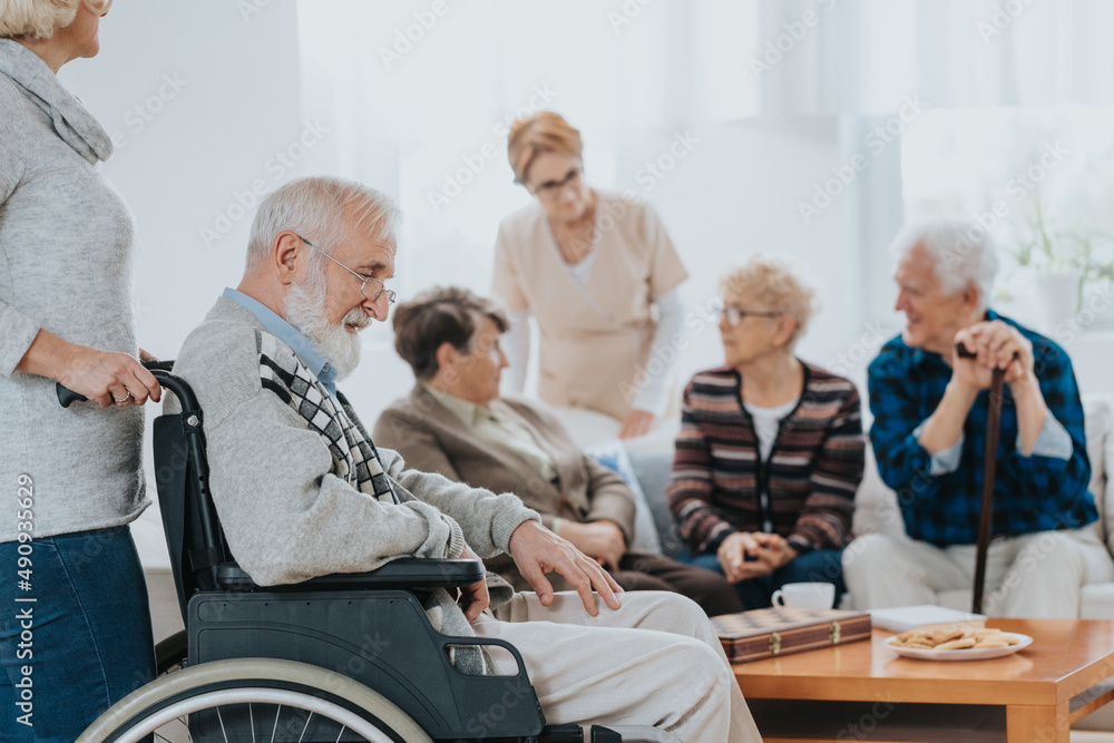 Volunteer helps seniors living in a care home for elderly Volunteer helps seniors living in a care home for elderly