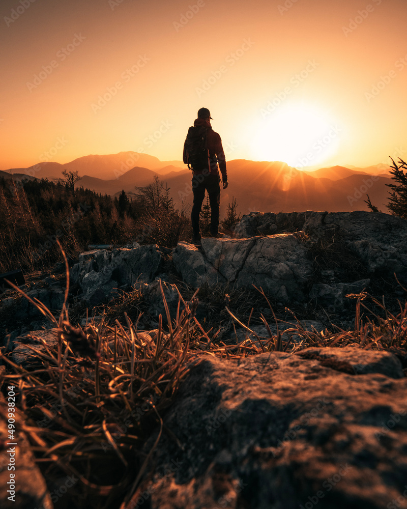 Person on Mountain Peak during Sunset on a warm summer Day - obrazy, fototapety, plakaty 