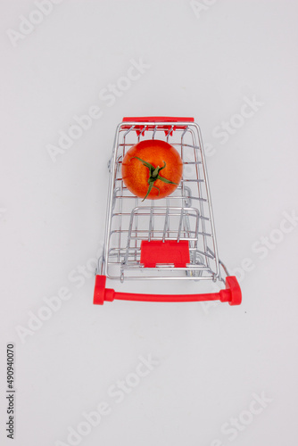 Tomatoes in metal basket on white background