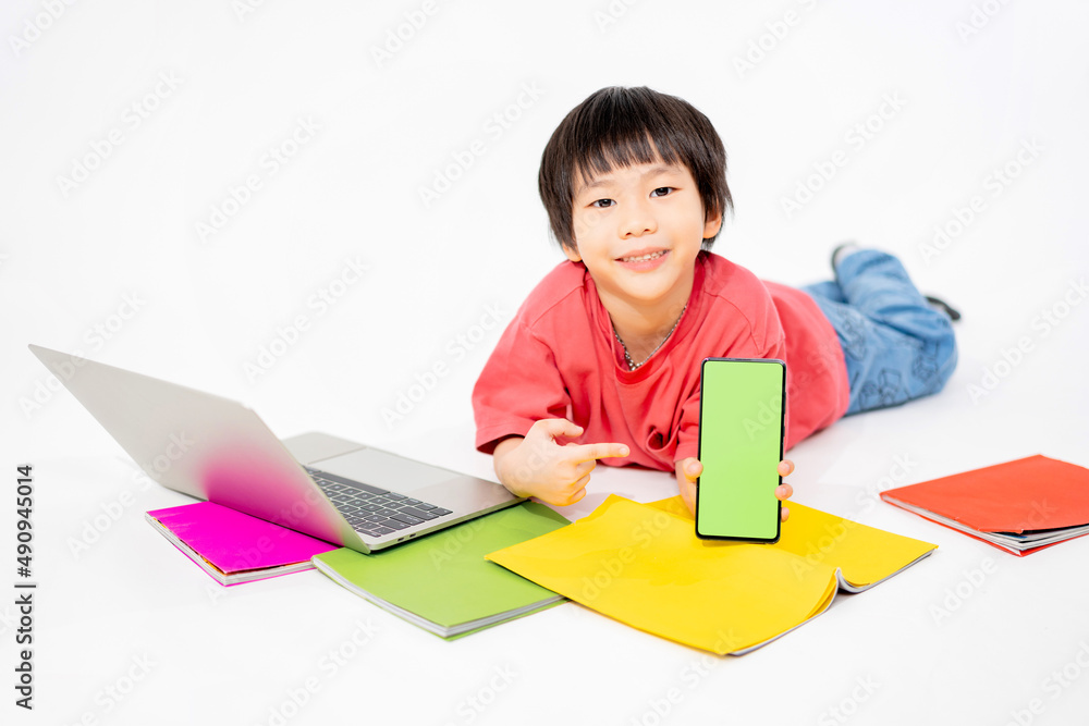 Portrait of Happy asian boy holding a phone in his hands with a green screen on floor with with laptop and books isolated on white background with copy space, Education and learning with technology Portrait of Happy asian boy holding a phone in his hands with a green screen on floor with with laptop and books isolated on white background with copy space, Education and learning with technology