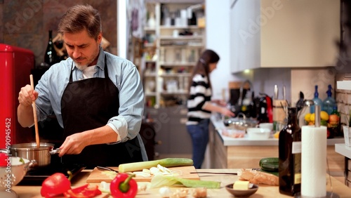 Bild auf Leinwand Caucasian couple cooking in the kitchen at home