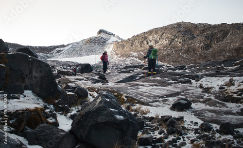 Two people mountaineering in alpine ecosystem on snowy glacier