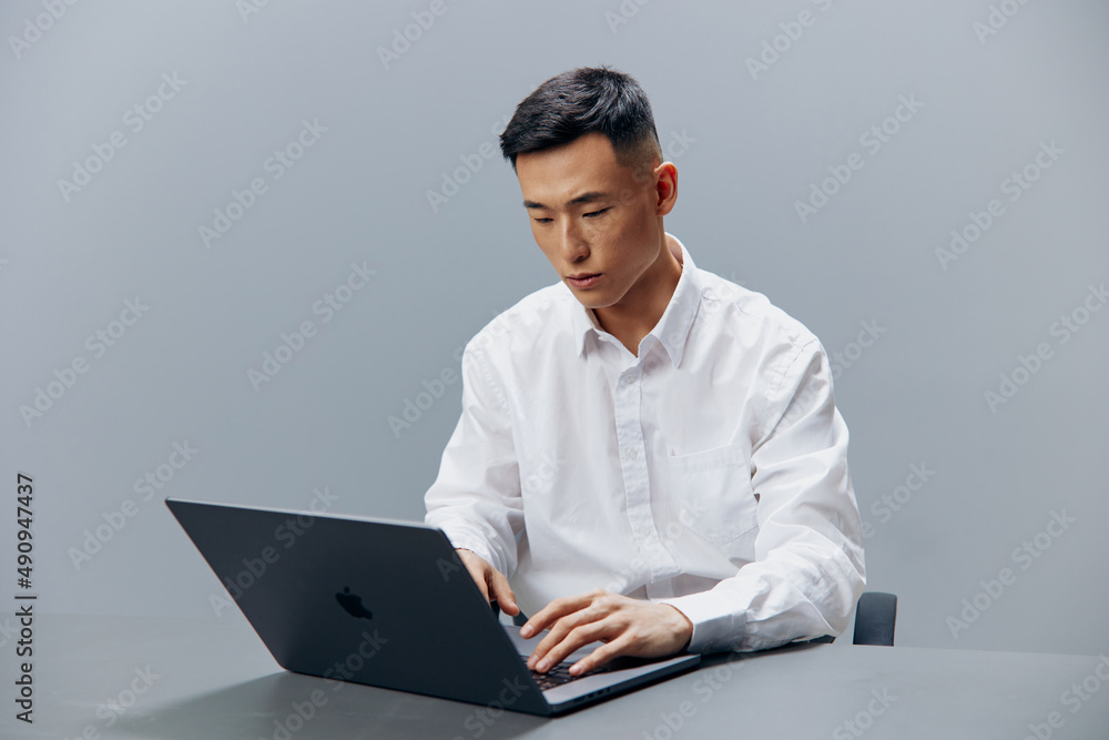 man working on a laptop sitting at a table in the office executive man working on a laptop sitting at a table in the office executive