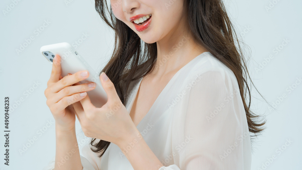 スマートフォンを手に笑顔の女性