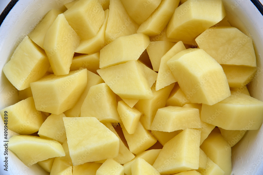 Peeled potatoes in strips in a white saucepan Peeled potatoes in strips in a white saucepan