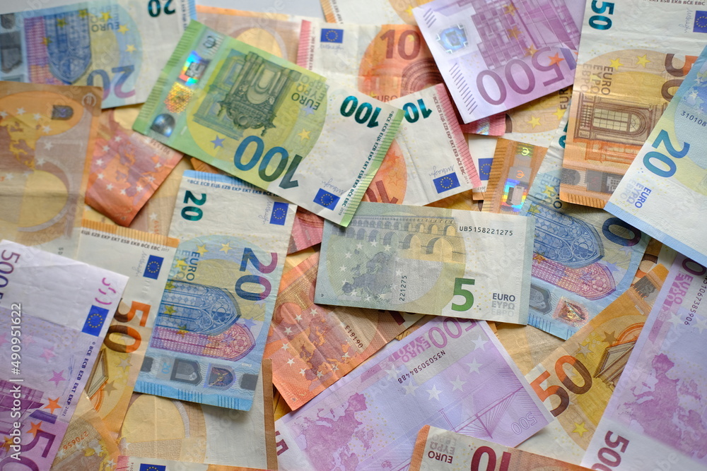 closeup paper 5,100, 50 euro banknotes of european union against background of scattered paper banknotes on table, concept of payments, savings, banking, save up for vacation, cash out currency closeup paper 5,100, 50 euro banknotes of european union against background of scattered paper banknotes on table, concept of payments, savings, banking, save up for vacation, cash out currency