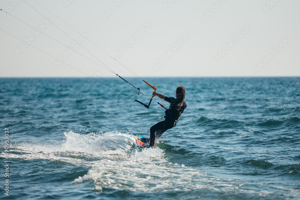 Woman kitesurfing on the ocean waters Woman kitesurfing on the ocean waters