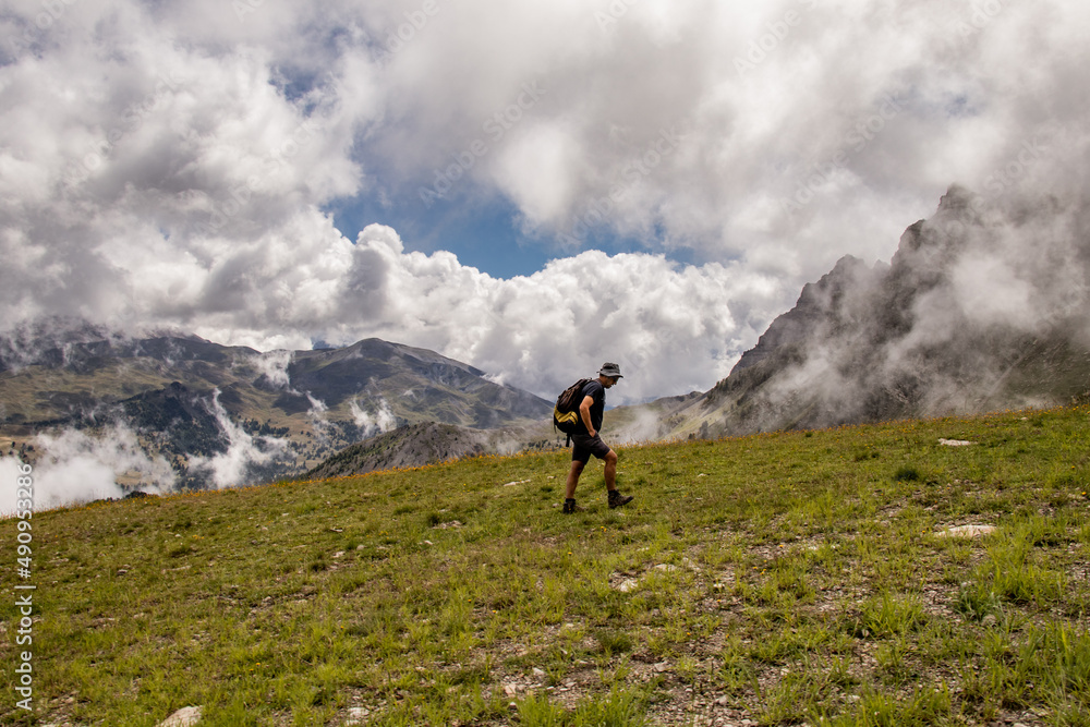 Hiker climbing a mountain in French Alpes in Vars