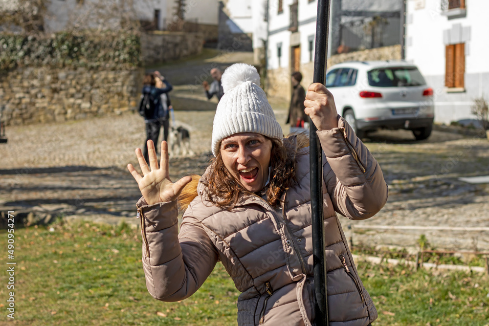 Obraz premium Woman with white hat hanging from a zip line while waving