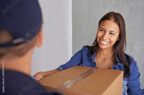 Always find a trustworthy moving company. A beautiful young woman smiling at the camera as she takes a box from a mover. © Jeff B/peopleimages.com