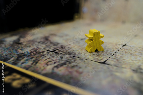 Yellow Wooden cowboy meeple on a gaming board