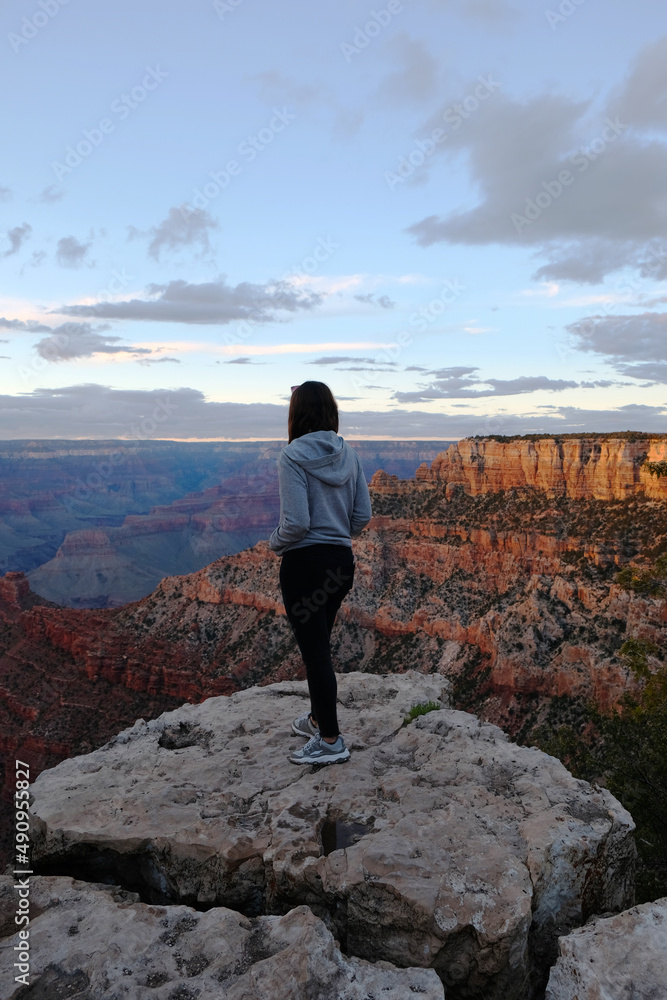 Obraz premium Woman staring at Grand Canyon during sunset, Arizona, United States