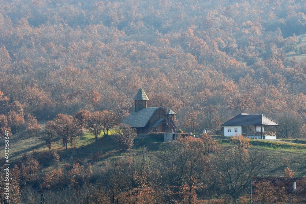 a wooden church on a hill in the fall