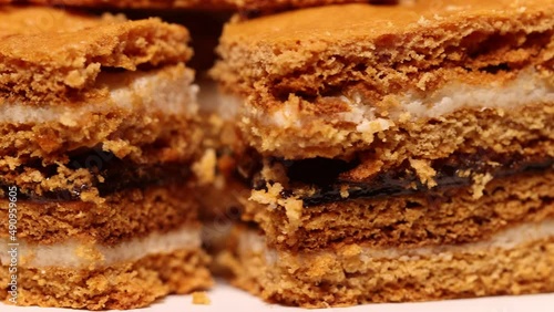 Wallpaper Mural Traditional homemade Romanian Honey Layered Cake with plum jam and semolina cream also called Albinita, close up. Cut portions of cake are on a cake stand, rotating against a yellow background. Torontodigital.ca