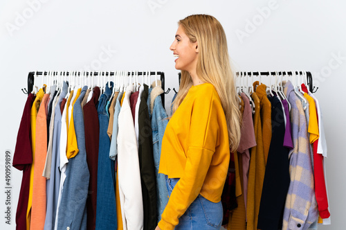 Young Uruguayan blonde woman in a clothing store laughing in lateral position