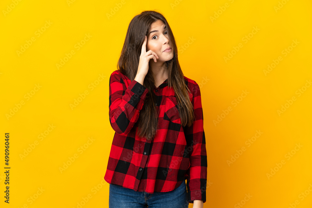 Teenager Brazilian girl isolated on yellow background thinking an idea Teenager Brazilian girl isolated on yellow background thinking an idea