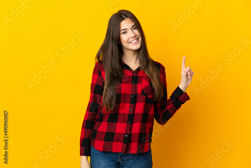 Teenager Brazilian girl isolated on yellow background showing and lifting a finger in sign of the best