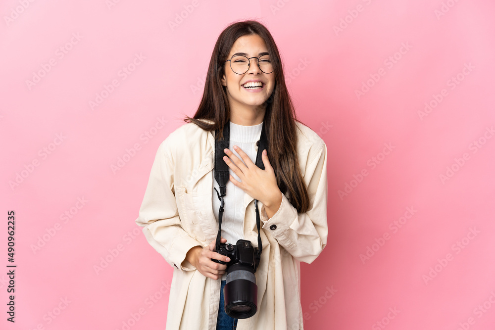 Young photographer Brazilian girl isolated on pink background smiling a lot Young photographer Brazilian girl isolated on pink background smiling a lot