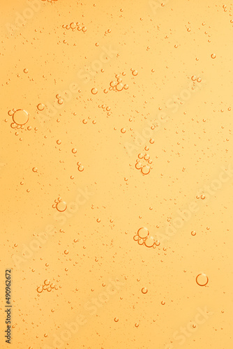 Cosmetic yellow water gel splash with bubbles texture background