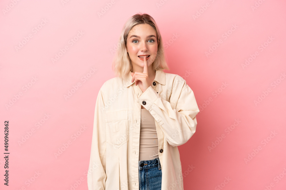 Young caucasian woman isolated on pink background showing a sign of silence gesture putting finger in mouth Young caucasian woman isolated on pink background showing a sign of silence gesture putting finger in mouth