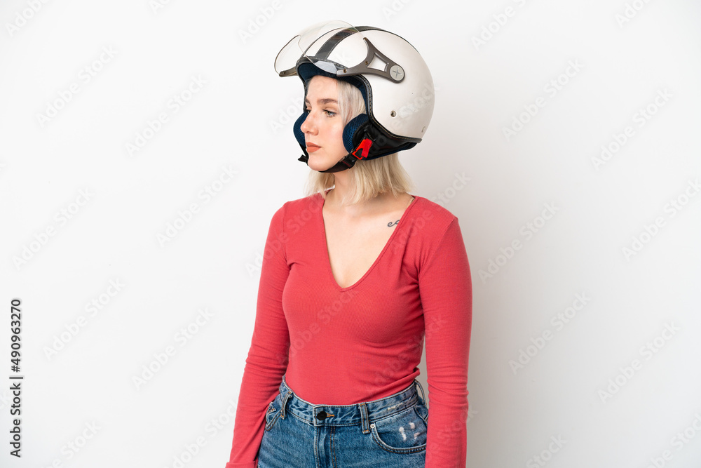 Young caucasian woman with a motorcycle helmet isolated on white background looking to the side Young caucasian woman with a motorcycle helmet isolated on white background looking to the side