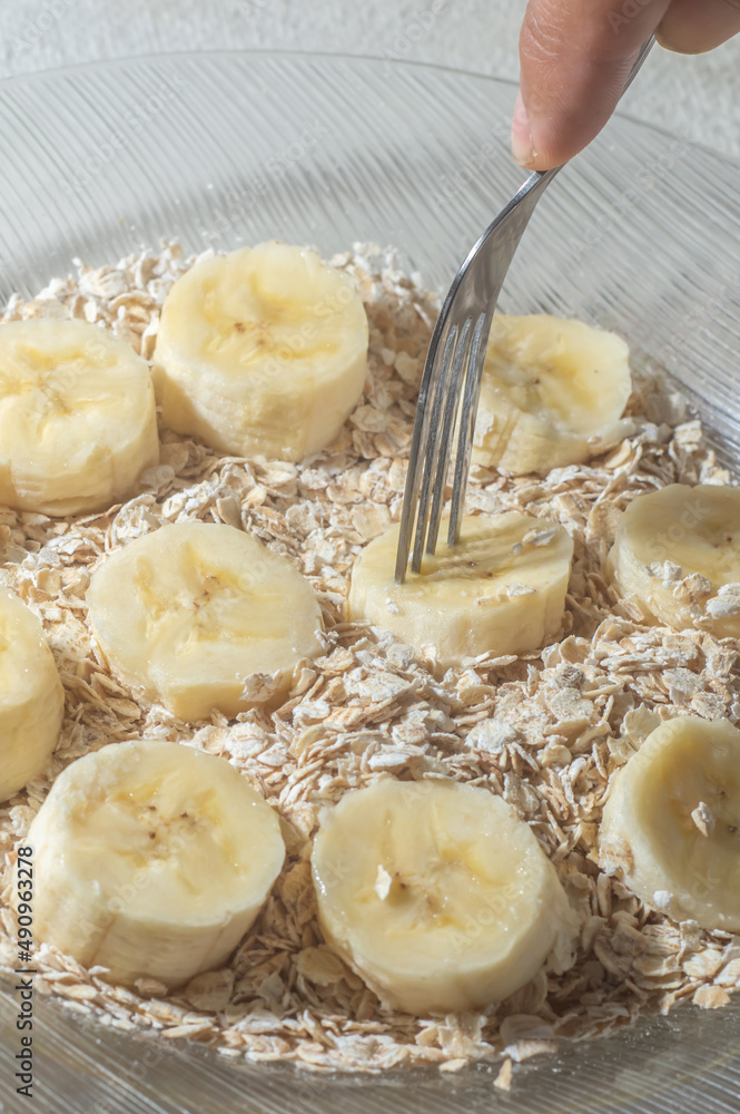 flaked oats and sliced banana, on a plate that is on a table with natural light,copy space in several parts flaked oats and sliced banana, on a plate that is on a table with natural light,copy space in several parts