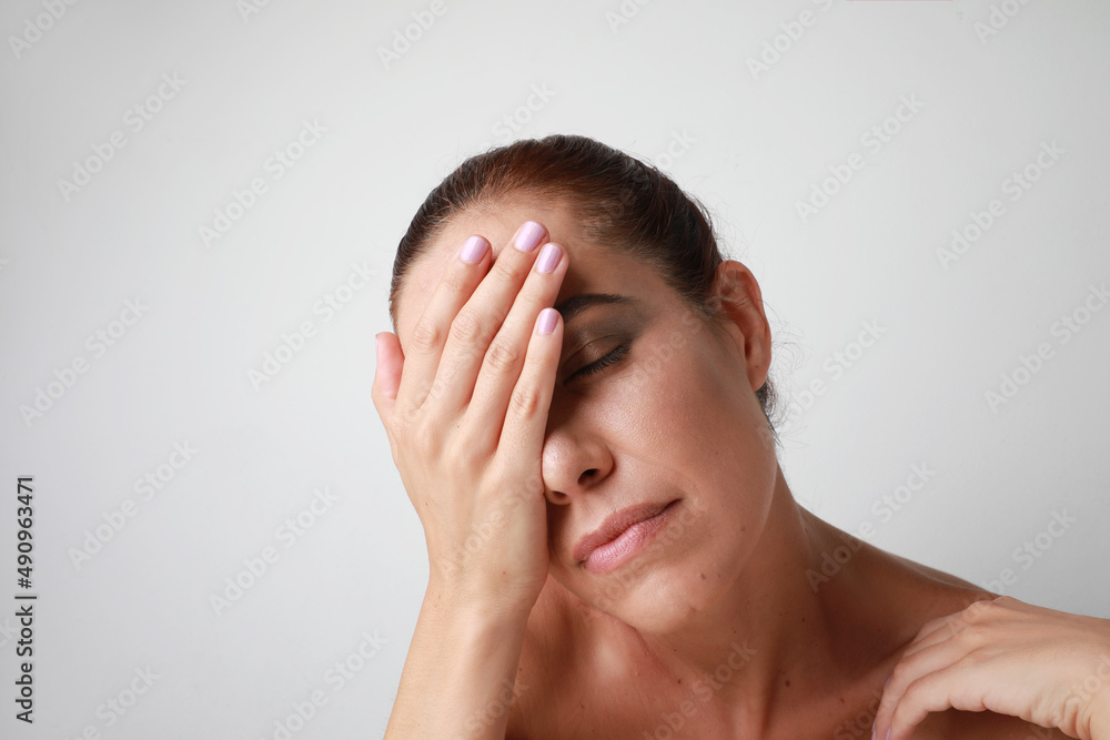 Young caucasian woman touches her face gently with hand. Mental health concept. Young caucasian woman touches her face gently with hand. Mental health concept.