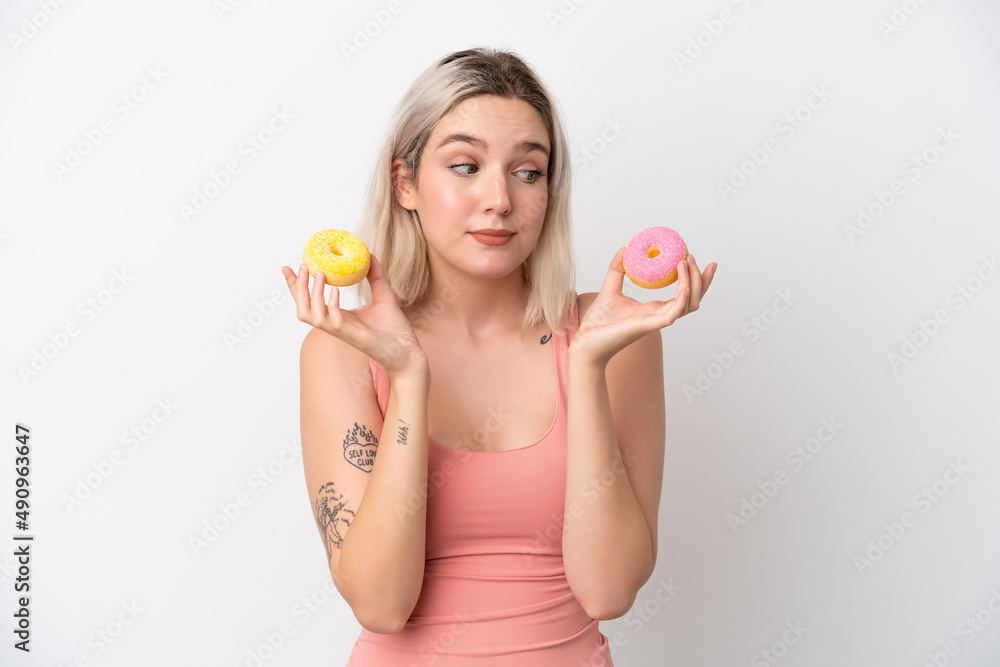 Young caucasian woman isolated on white background holding donuts