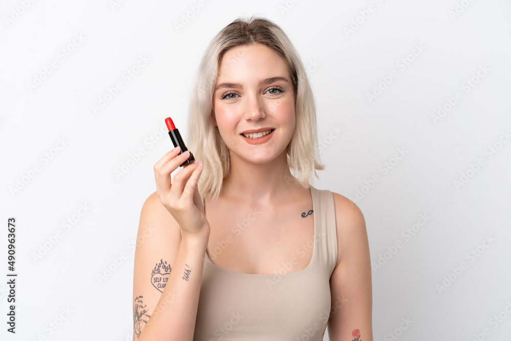 Young caucasian woman isolated on white background holding red lipstick Young caucasian woman isolated on white background holding red lipstick