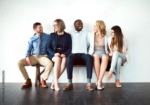 So what are you guys doing today. Shot of a group of work colleagues seated next to each other against a white background.