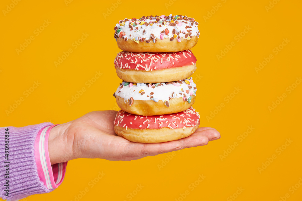 Young beautiful woman over yellow background with donuts Young beautiful woman over yellow background with donuts