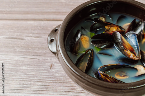 Honghaptang, Korean style Mussel Soup : Boil a pot of water with radish and red and green pepper and then add mussels. Bring all ingredients to a boil together for a while. This hearty soup is prepare photo