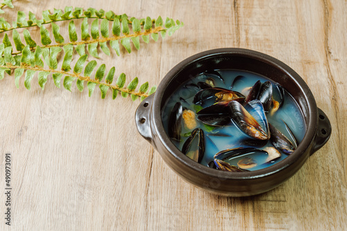 Honghaptang, Korean style Mussel Soup : Boil a pot of water with radish and red and green pepper and then add mussels. Bring all ingredients to a boil together for a while. This hearty soup is prepare photo