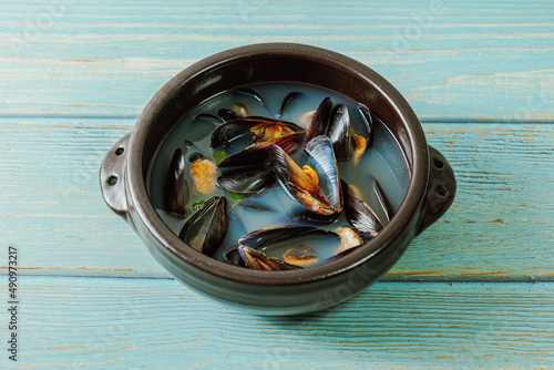 Honghaptang, Korean style Mussel Soup : Boil a pot of water with radish and red and green pepper and then add mussels. Bring all ingredients to a boil together for a while. This hearty soup is prepare photo