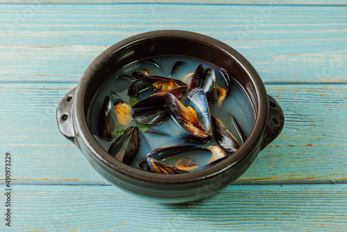 Honghaptang, Korean style Mussel Soup : Boil a pot of water with radish and red and green pepper and then add mussels. Bring all ingredients to a boil together for a while. This hearty soup is prepare photo