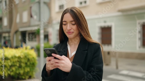 Wallpaper Mural Young hispanic woman smiling confident using smartphone at street Torontodigital.ca