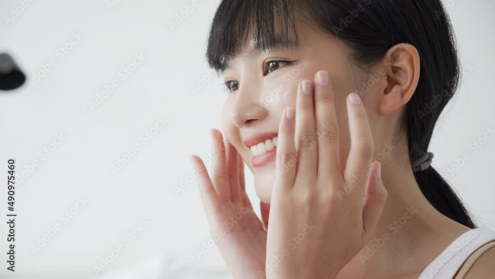 Beautiful young asian woman happy applying cream or lotion with moisturizer to skin on face, beauty asia girl applying skincare touch facial with cosmetic makeup, skin care and health concept. Beautiful young asian woman happy applying cream or lotion with moisturizer to skin on face, beauty asia girl applying skincare touch facial with cosmetic makeup, skin care and health concept.